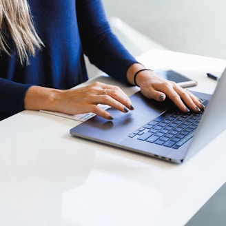 woman in blue long sleeve shirt using macbook pro