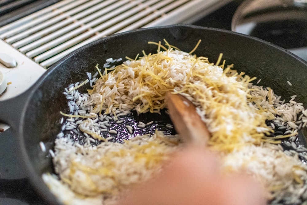 cooked rice on black frying pan