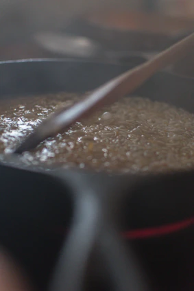 A polished stainless steel saucepan filled with simmering sauce on a modern kitchen counter