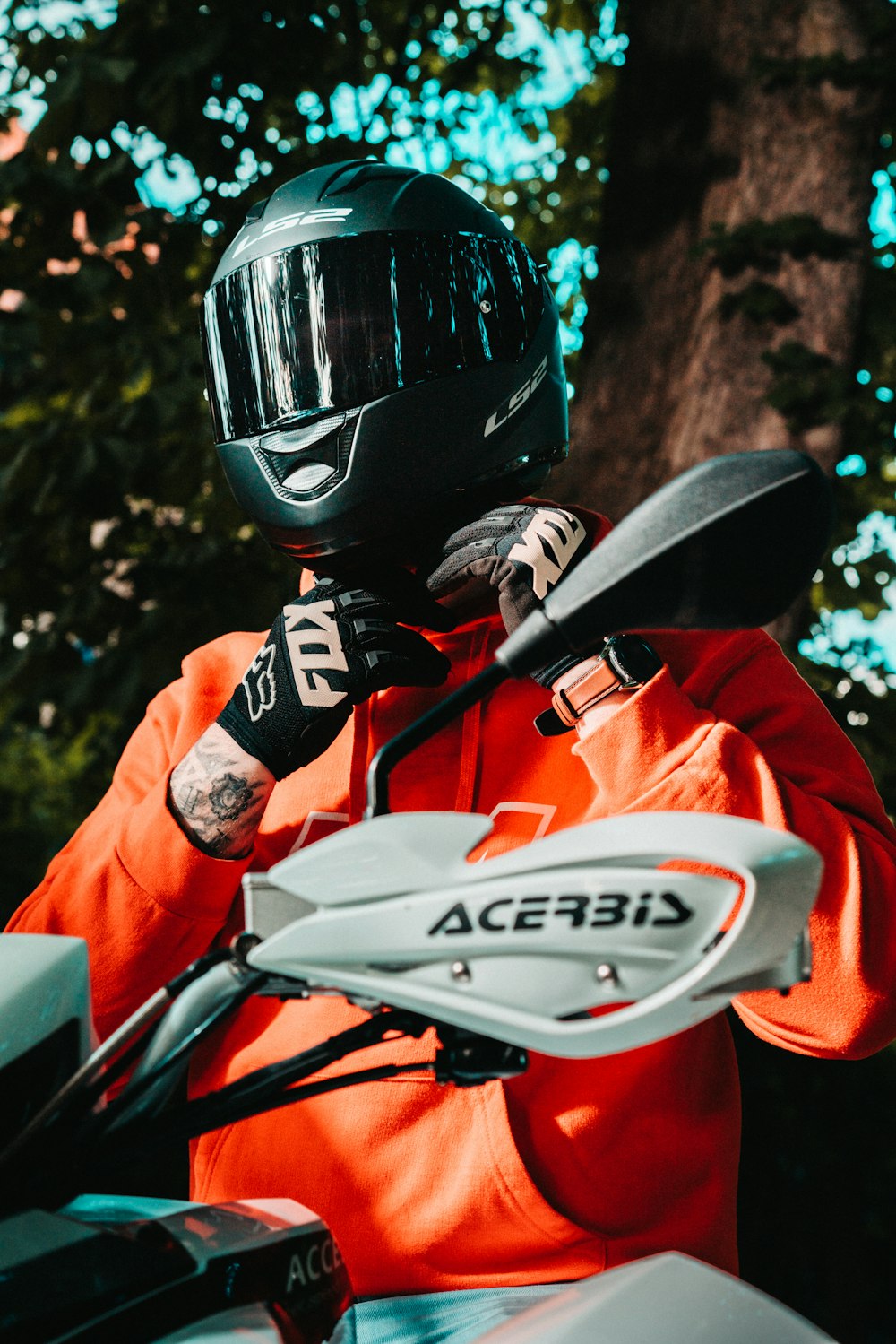 man in red jacket wearing black helmet riding on motorcycle