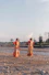 2 women walking on brown sand near body of water during daytime