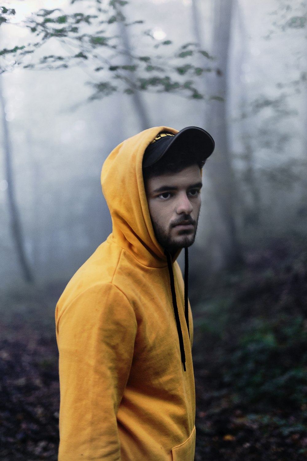 man in yellow hoodie wearing black cap