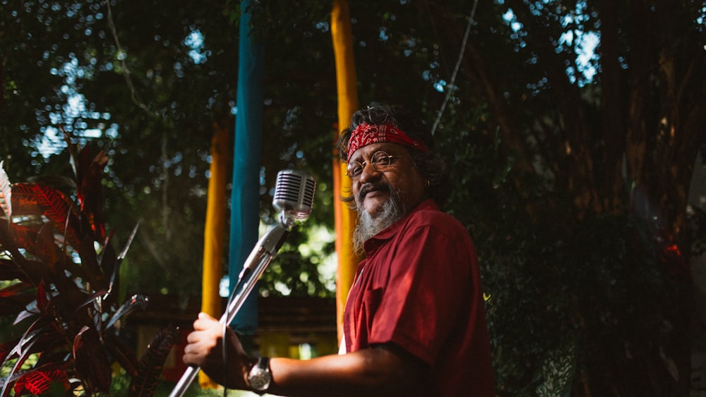 man in red crew neck t-shirt holding microphone