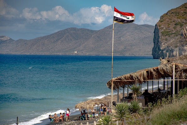 people on beach during daytimeby hosein charbaghi