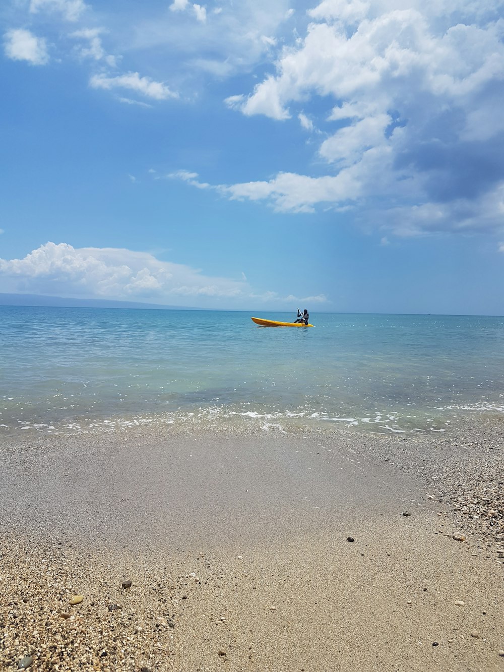 yellow and black boat on sea under blue sky during daytime