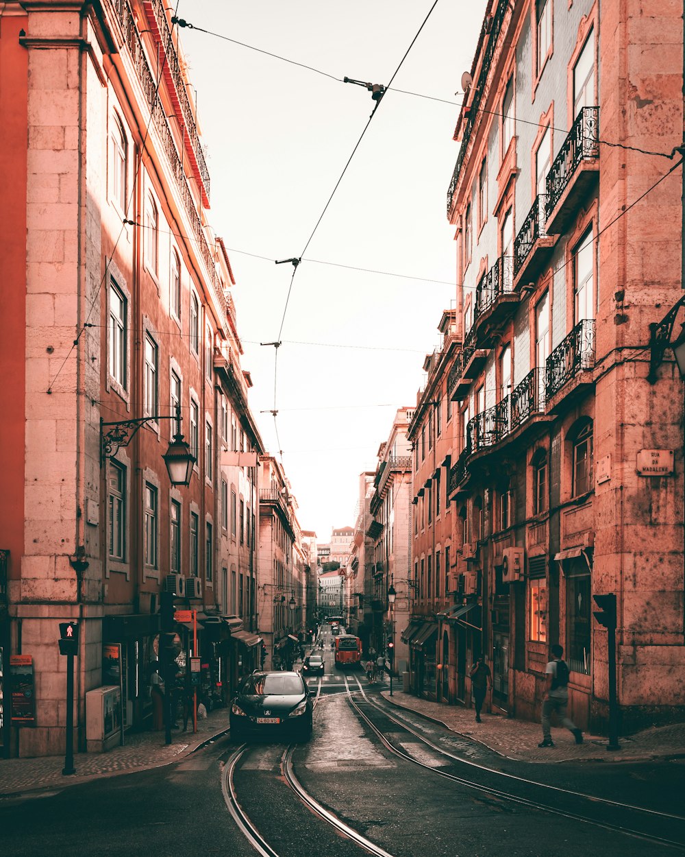 cars parked on side of the road in between buildings during daytime