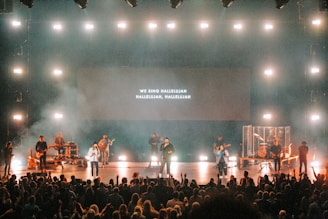 people sitting on chairs watching band performing on stage