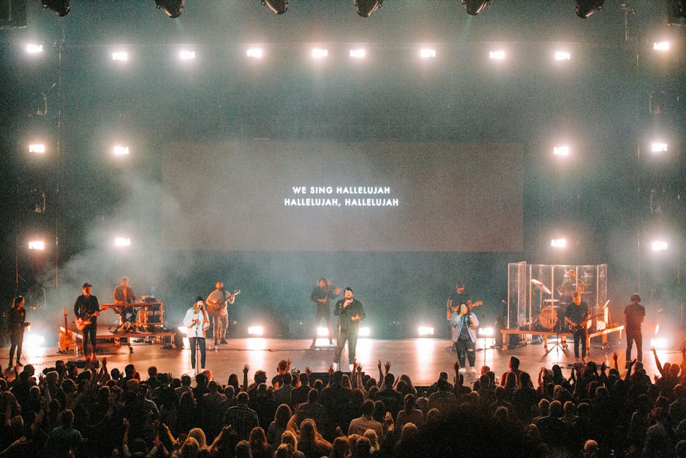 people sitting on chairs watching band performing on stage