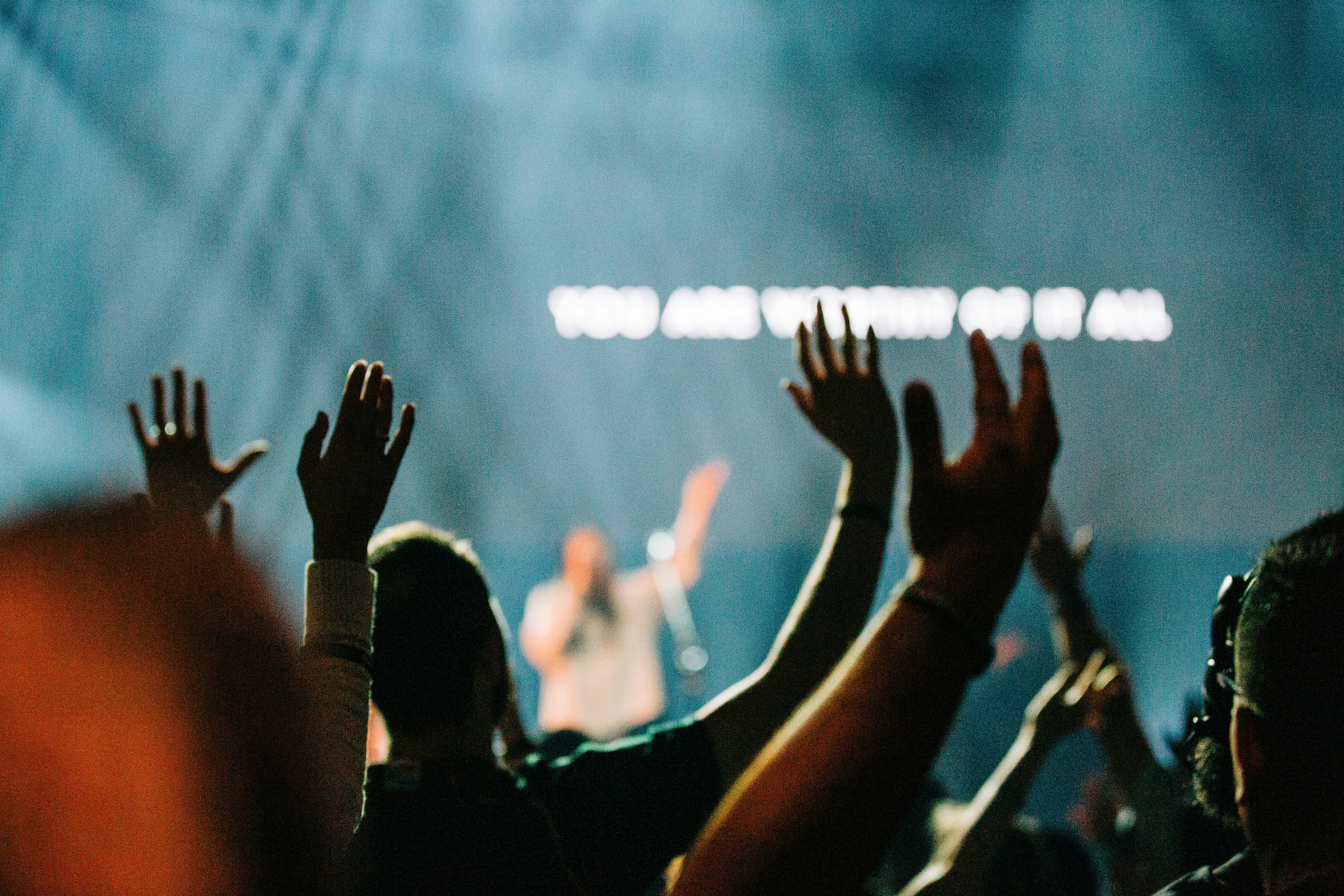 people raising their hands during daytime