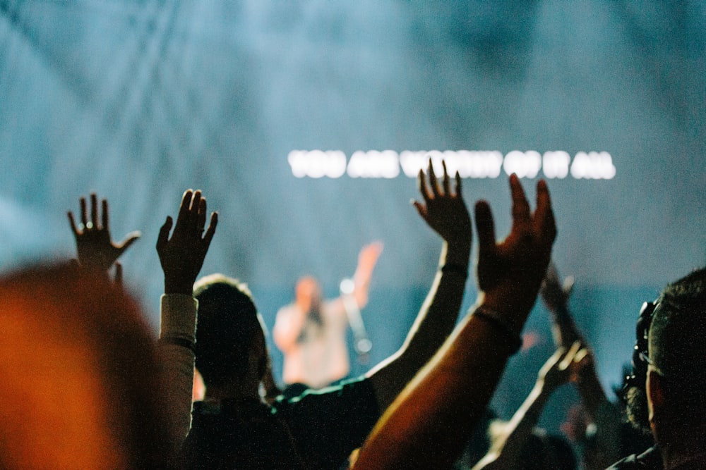 people raising their hands during daytime