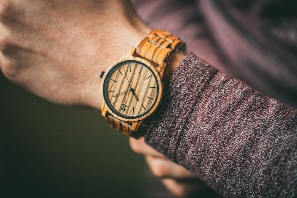 person wearing gold and silver round analog watch