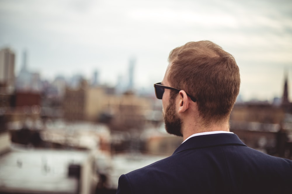 Hombre con chaqueta de traje negro con gafas de sol negras durante el día