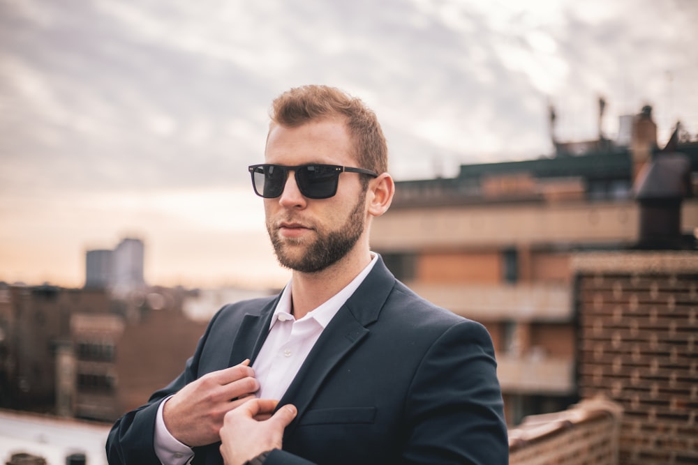 man in black suit jacket wearing black sunglasses