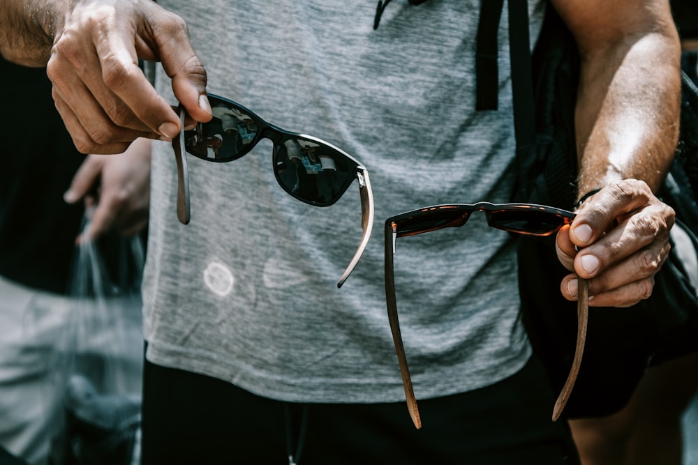 person holding black framed eyeglasses