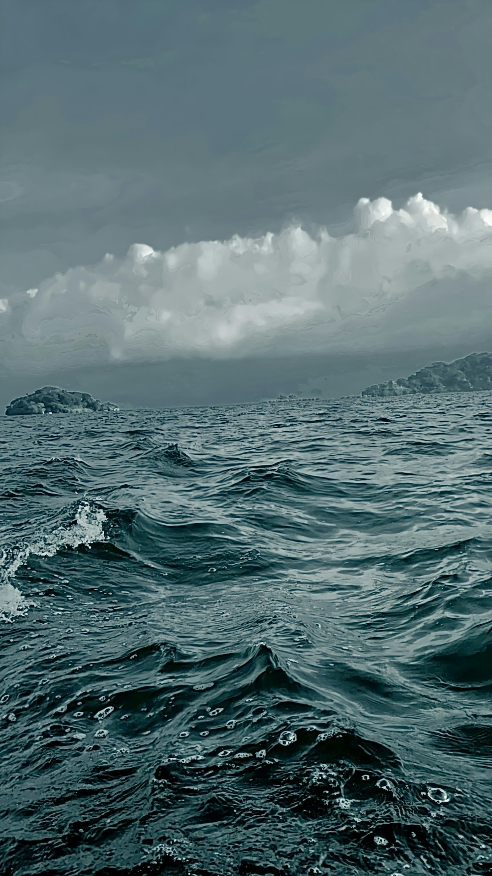 ocean waves under white clouds during daytime