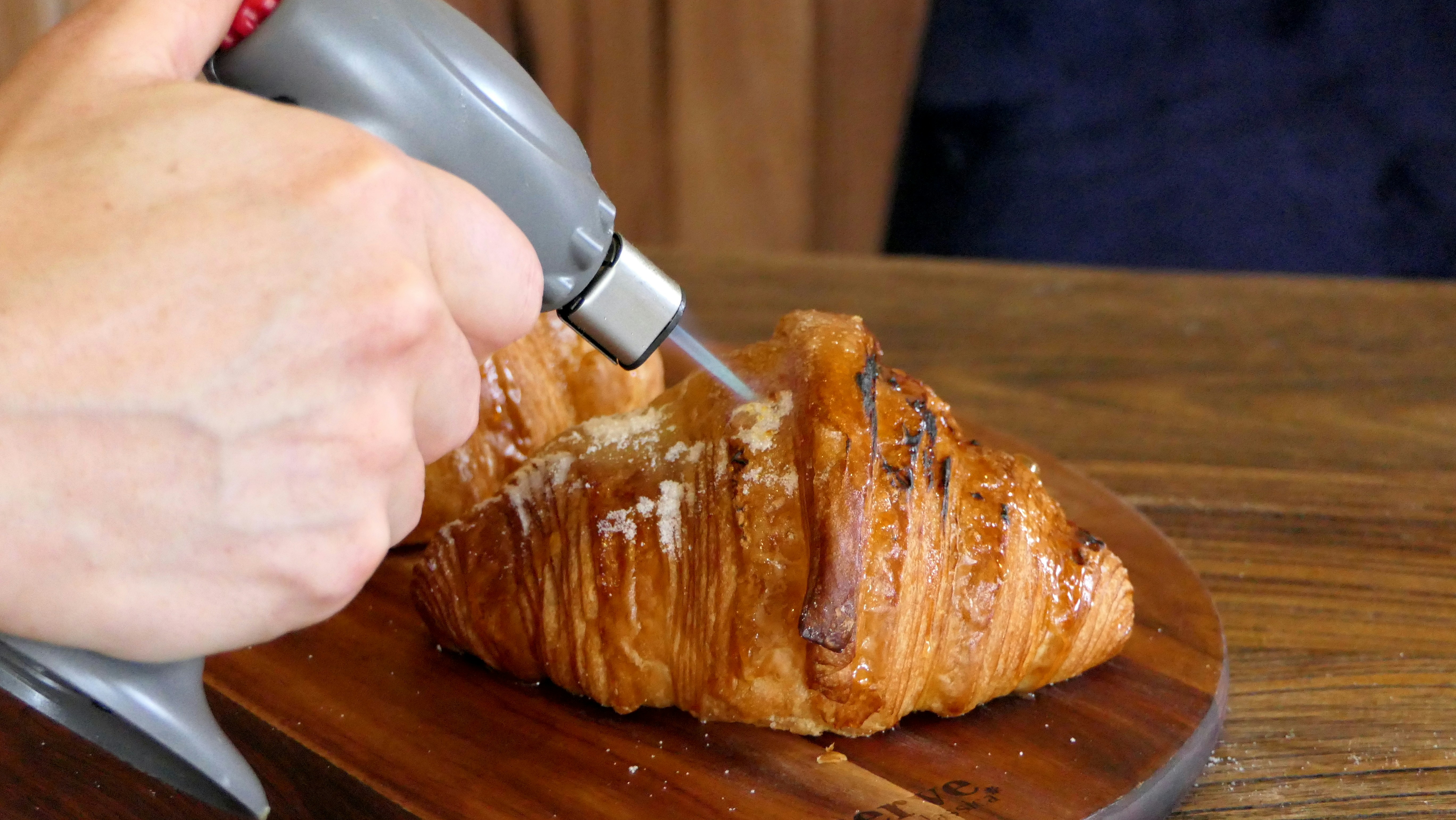 persona que sostiene un cuchillo cortando carne