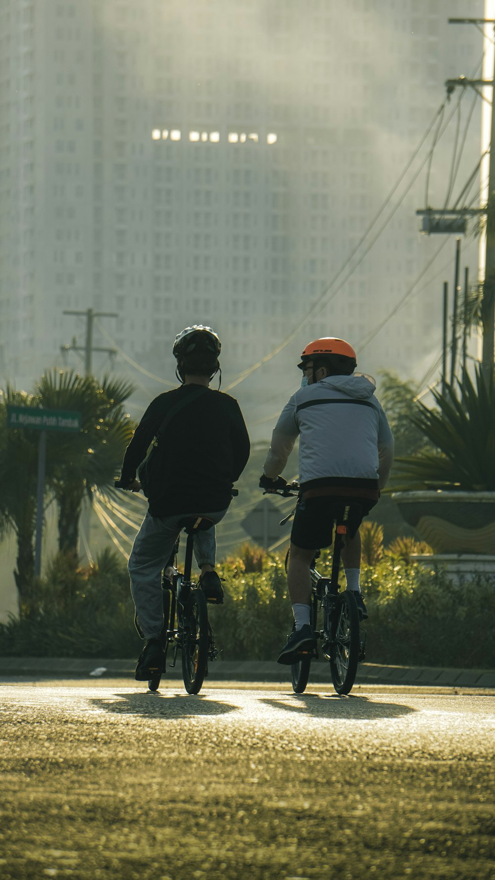 2 men riding bicycle on road during daytime