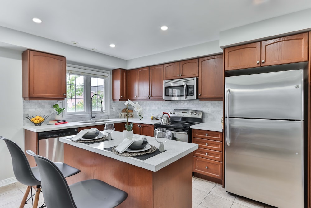 silver top mount refrigerator beside brown wooden kitchen cabinet