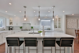 a kitchen with a center island with four chairs