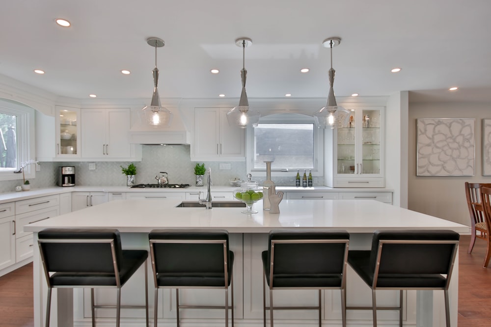 a kitchen with a center island with four chairs