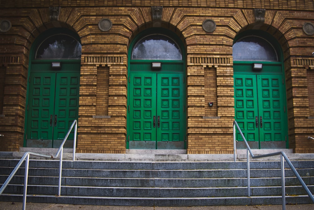 brown brick building with green wooden doors