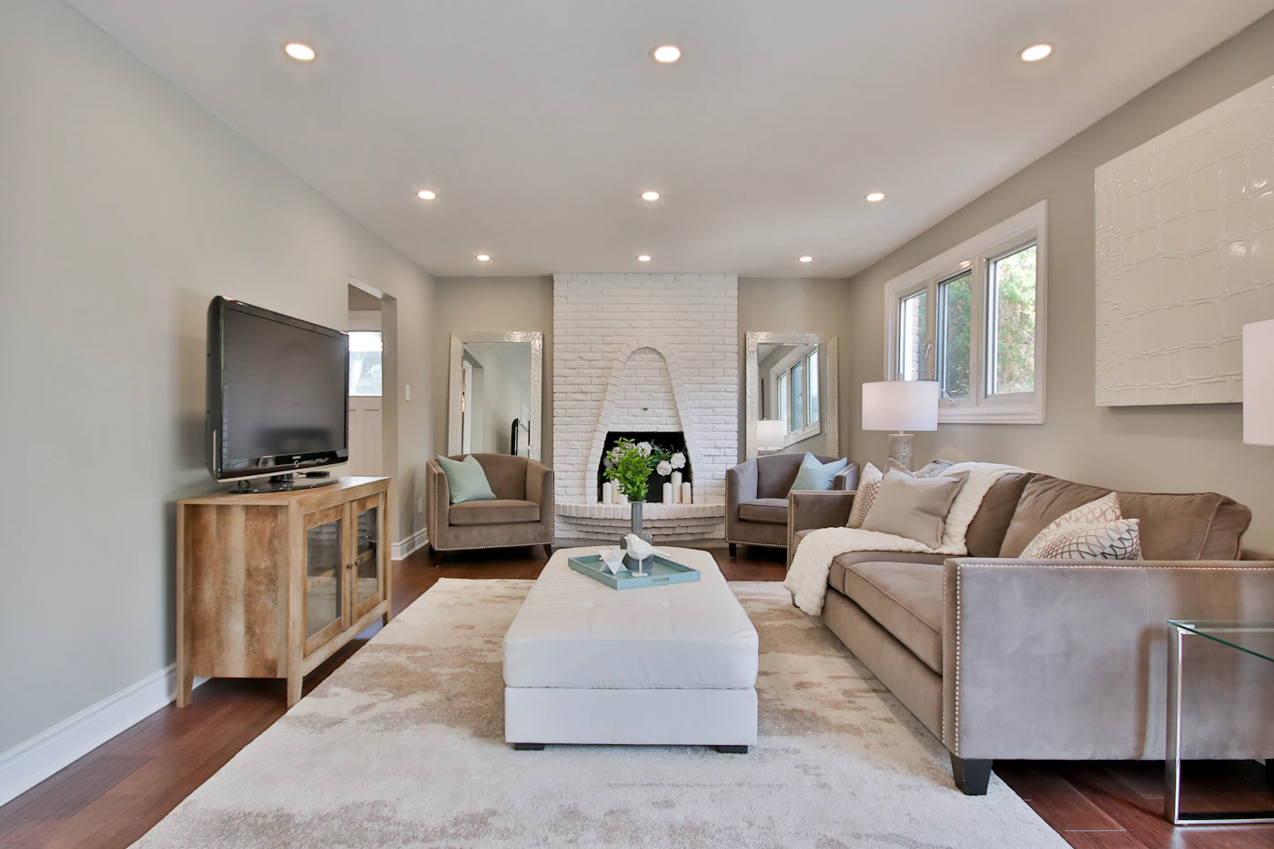 A white sofa facing a black flat-screen TV