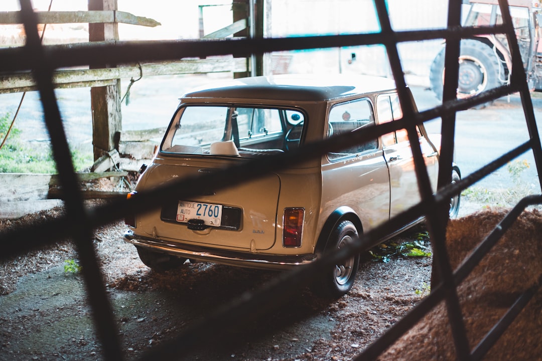 yellow car parked beside white wall