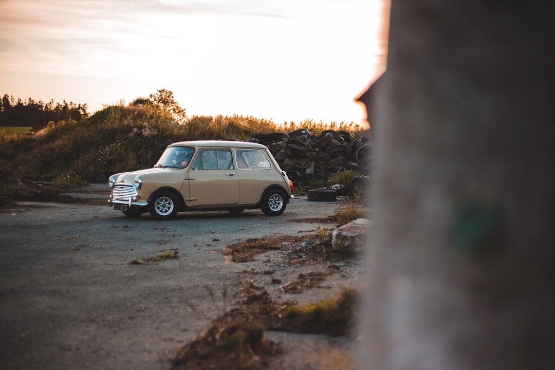 gray sedan on gray dirt road during daytime