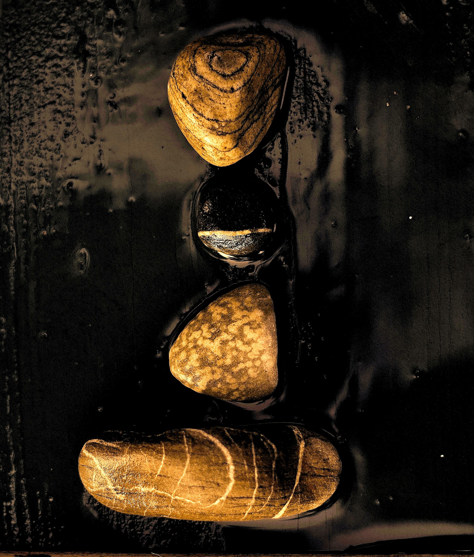 An artistic display of stacked granite tiles in varying shades of black and gold, emphasizing the craftsmanship behind each piece.