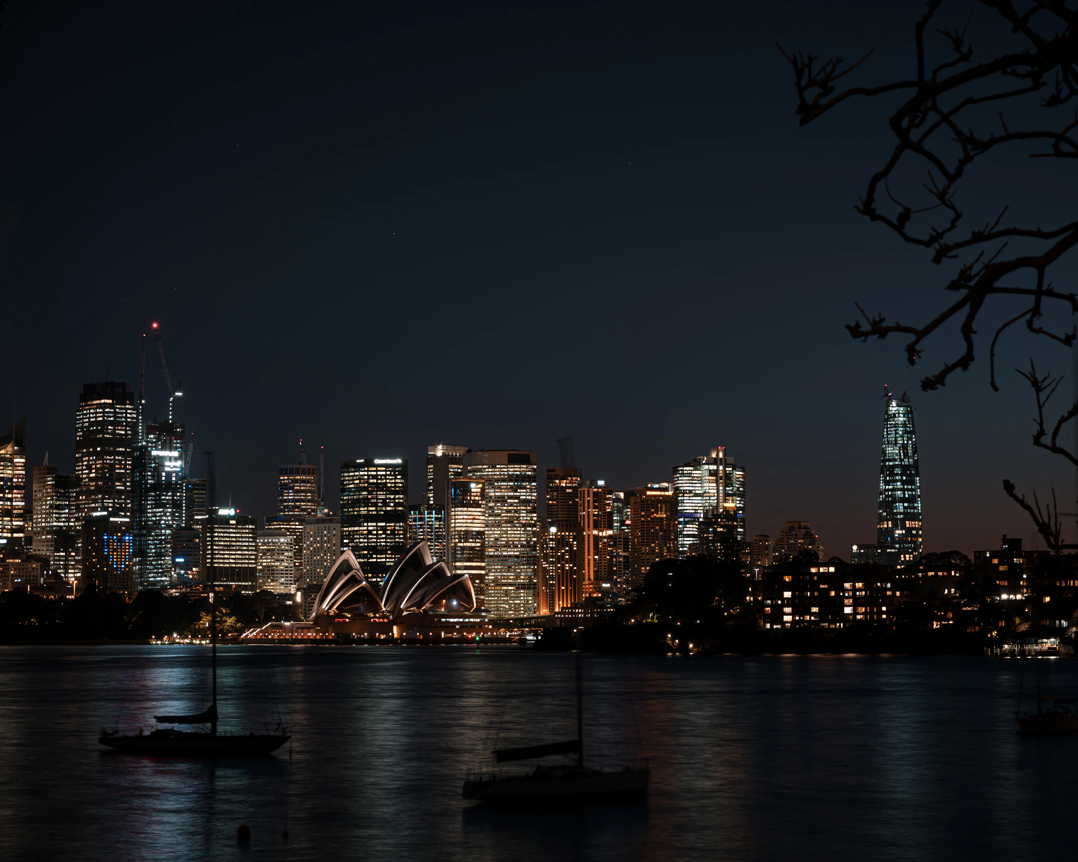 Sydney Opera House and harbour at blue hour with the city lit behind