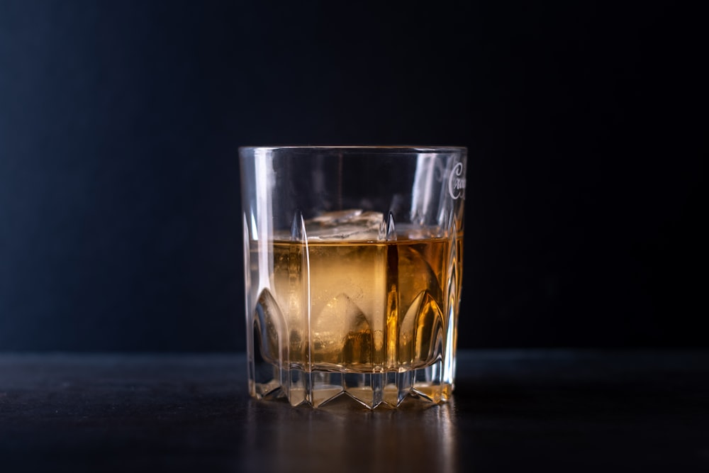 clear shot glass with brown liquid