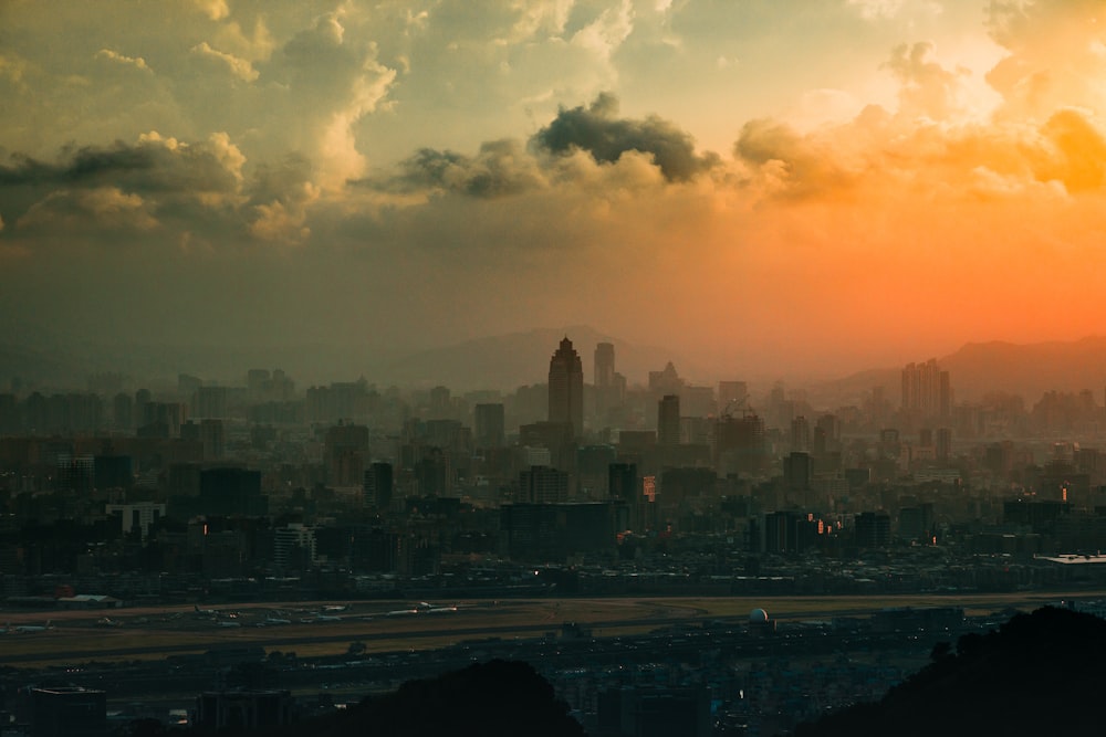 city skyline under cloudy sky during sunset