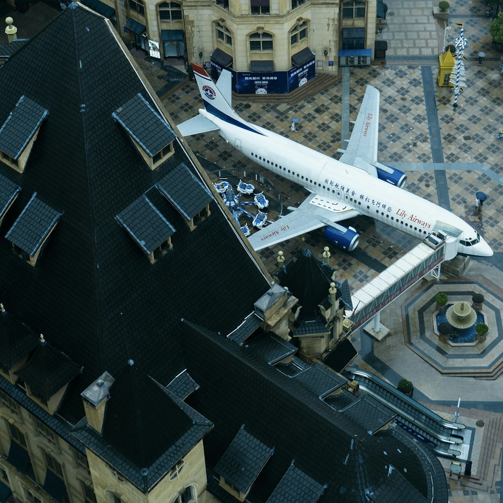 white airplane in the city during daytime