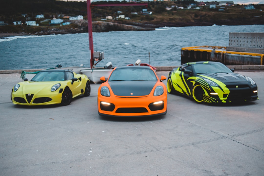 yellow and black lamborghini aventador parked on gray concrete pavement near body of water during daytime