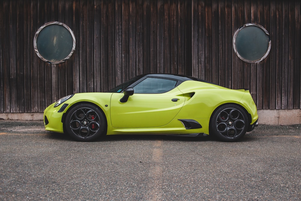 yellow ferrari 458 italia parked beside brown wooden wall