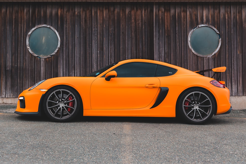 orange ferrari 458 italia parked beside brown wooden wall