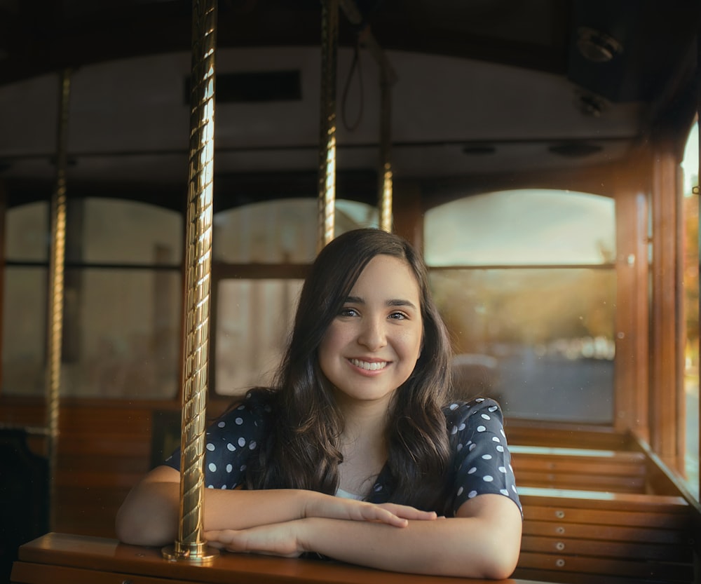 woman in blue and white polka dot shirt smiling