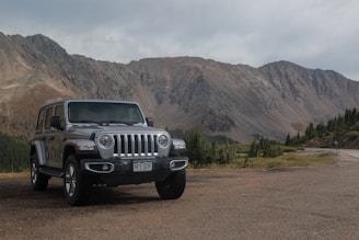 black jeep wrangler on dirt road near mountain during daytime