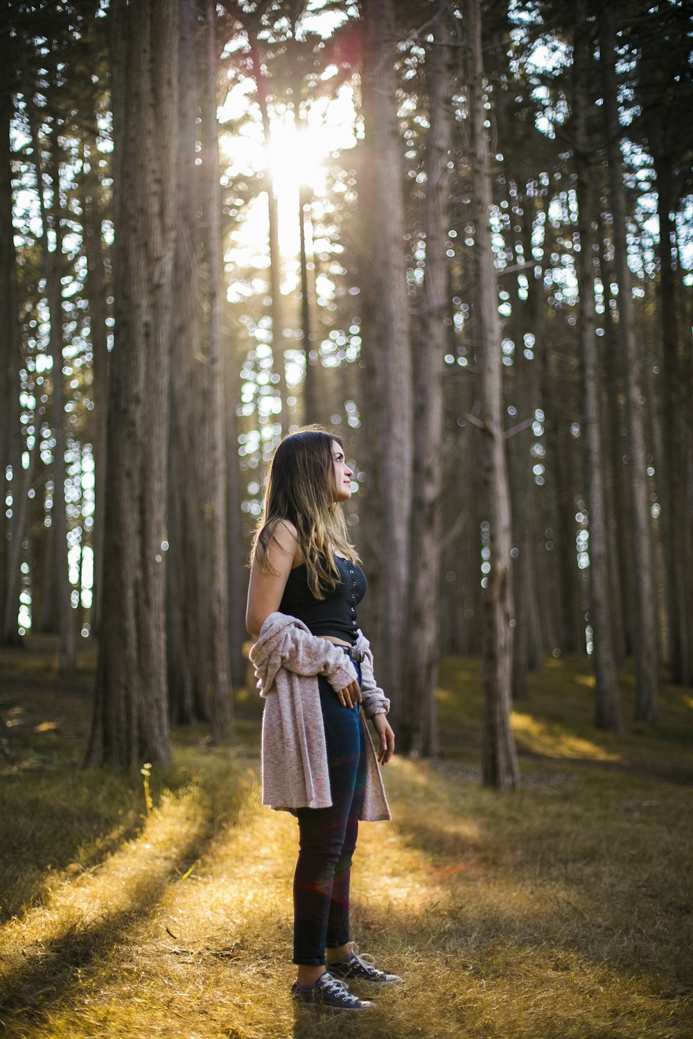 woman in gray long sleeve shirt and red skirt standing on green grass field surrounded by