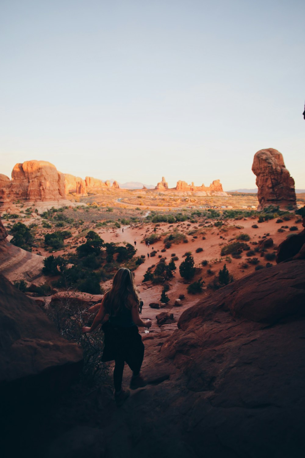 woman in black jacket standing on brown rock formation during daytime