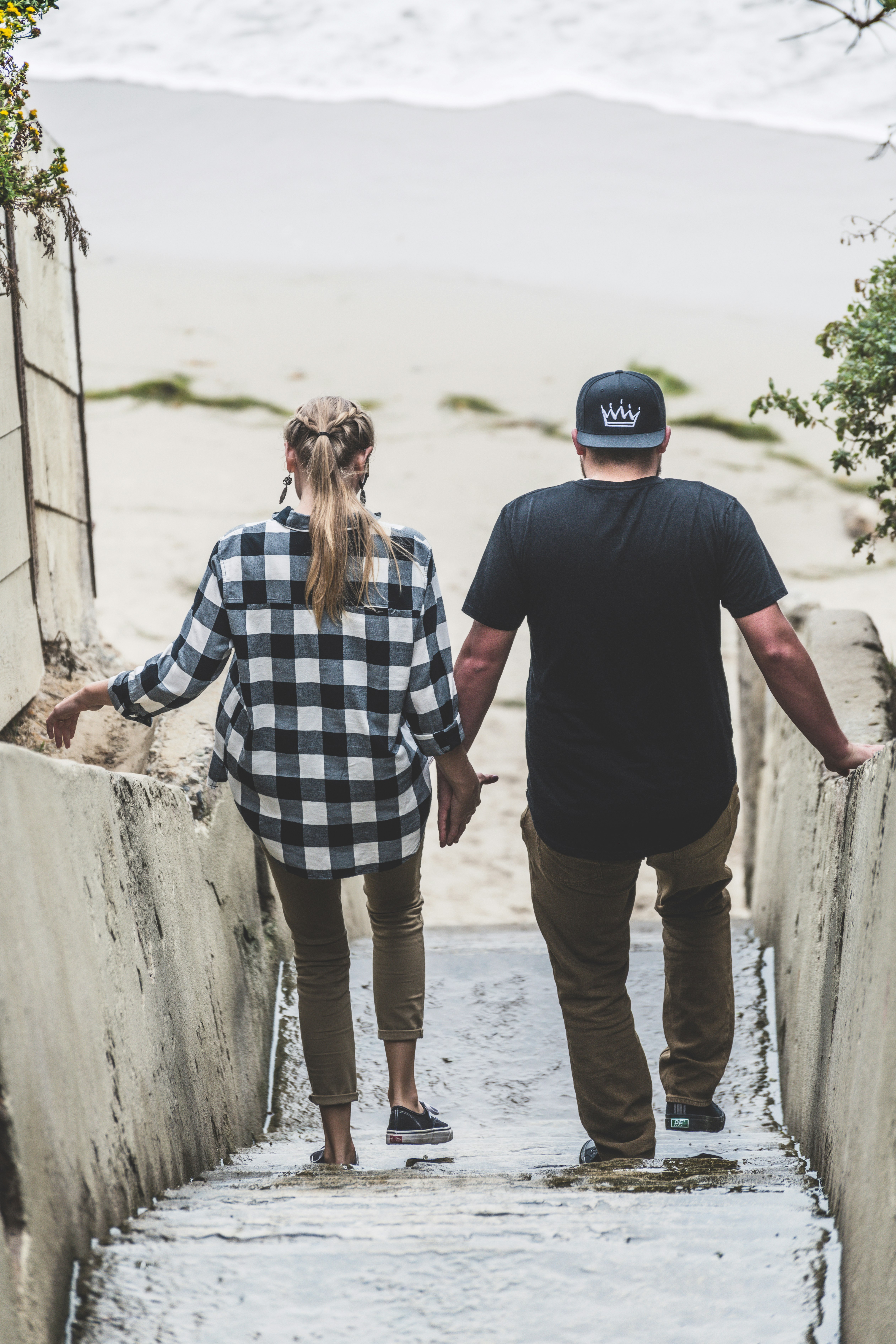 man and woman standing on beach during daytime