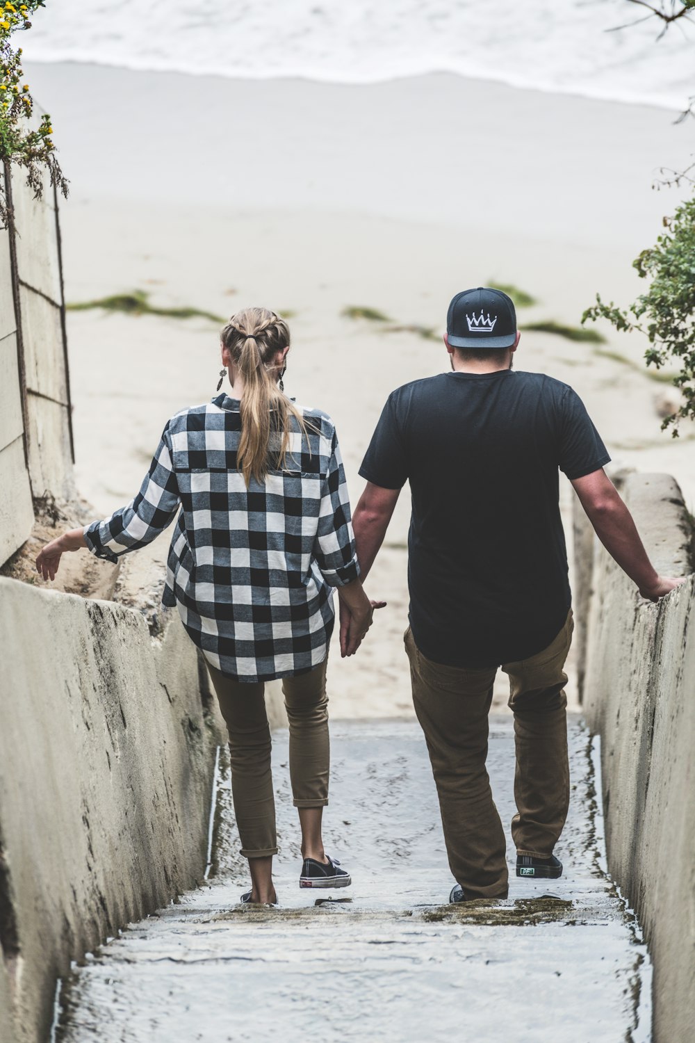 man and woman standing on beach during daytime