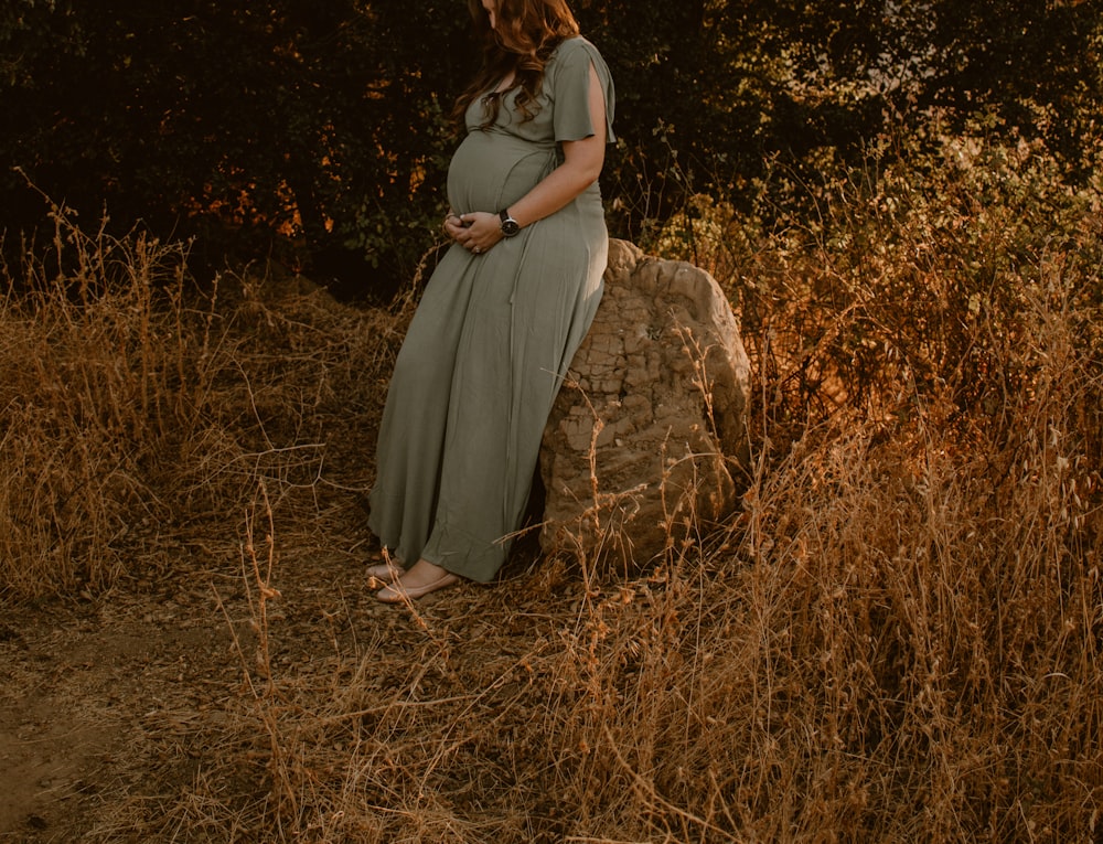 woman in gray dress standing on brown grass field