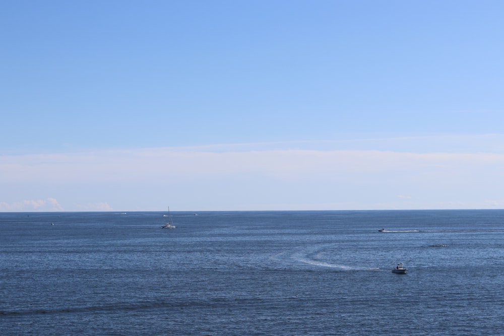 boat on sea under blue sky during daytime