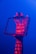 A hand is holding a transparent rectangular frame against a blue background. Red light projects the word 'DREAM' multiple times onto the hand and frame, creating a vivid contrast.