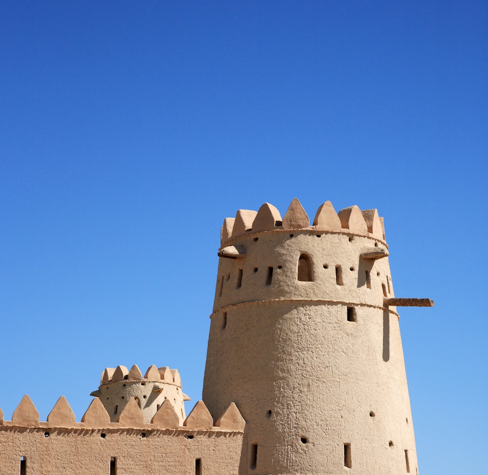 castello di cemento grigio sotto il cielo blu durante il giorno