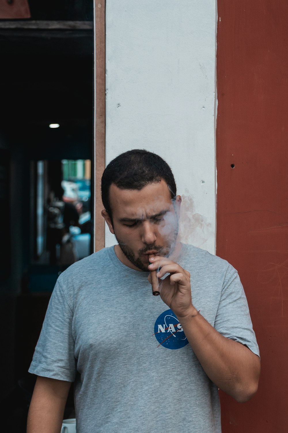 man in gray crew neck t-shirt smoking cigarette