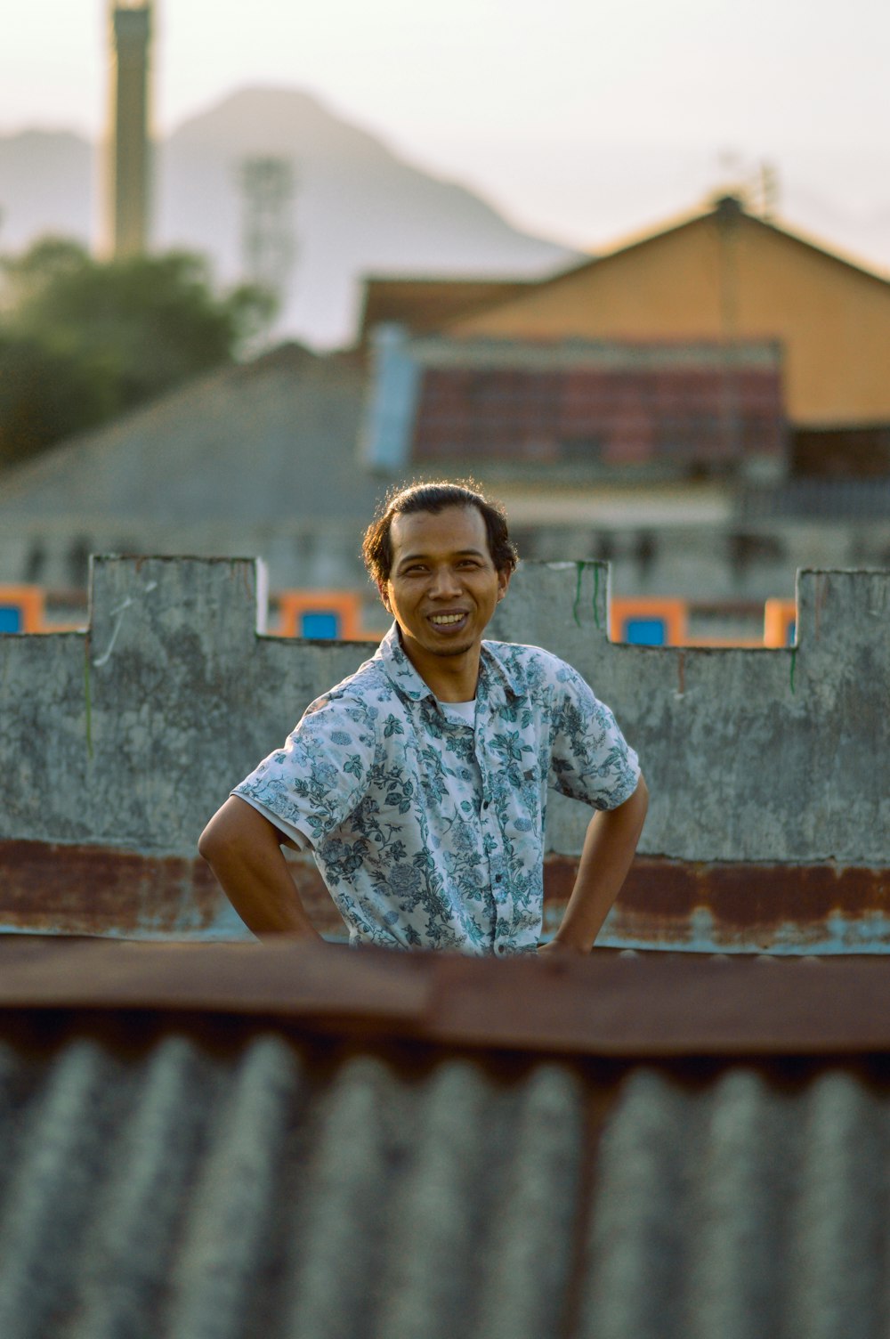 man in blue and white floral button up t-shirt standing on brown wooden stairs during