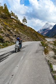 A rider on a motorcycle cruising along a scenic mountain road.