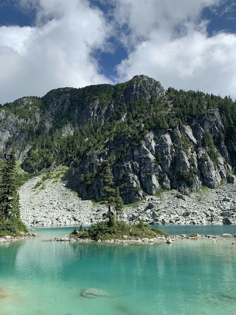 green and gray mountain beside body of water during daytime